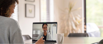 Женщина сидит за экраном компьютера во время видеосвязи с врачом