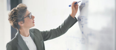 Businesswomen writing on a whiteboard