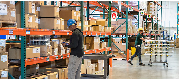 Workers inventorying and organizing items in a warehouse.
