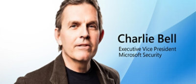 「Charlie Bell, Executive Vice President, Microsoft Security」と書かれたテキストがオーバーレイされた茶色のジャケットを着た男性のクローズアップ。