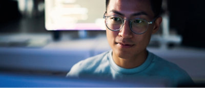 眼鏡をかけてコンピューター スクリーンを見ている人。