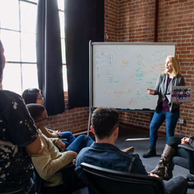A woman explaining through a whiteboard