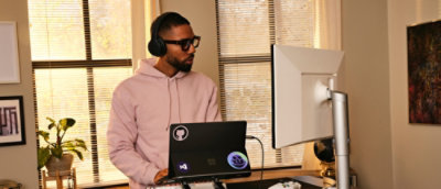 A person wearing headphones and using a laptop.