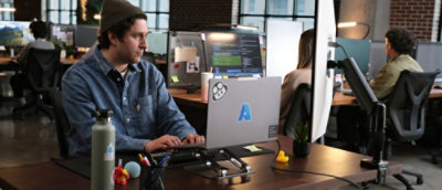 A person typing on a laptop at a desk.