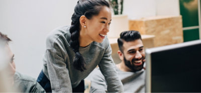 Small group collaborating around a computer screen in a shared workspace.