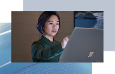 Person standing and interacting with a large touchscreen device in a modern workspace.