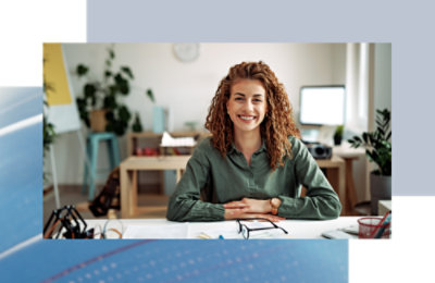 Person seated at a desk, working at a computer in a home office setting.