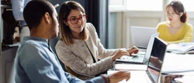 A man and woman looking at a laptop.