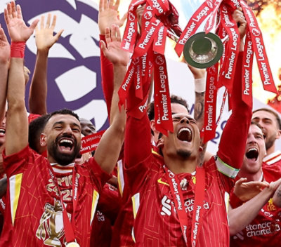 A group of football players in red jerseys celebrating with their arms raised, with visible text related to the Premier League.