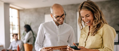 A person and another person looking at a tablet