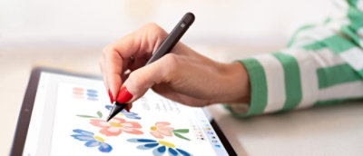 A hand holding a pen over a piece of paper.