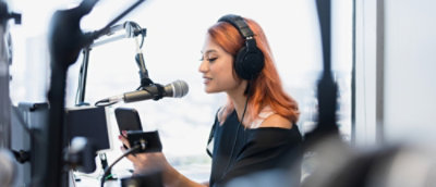 A person wearing headphones and holding a phone.