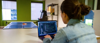 A person typing on a laptop in a blurry image.