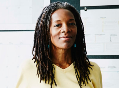 A woman with dreadlocks smiling.