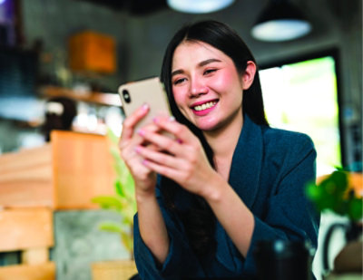  A woman sitting on a couch using a phone.