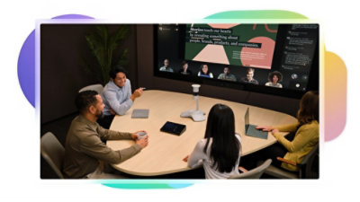 Three people sitting at a conference table viewing a screen with a Teams Rooms call