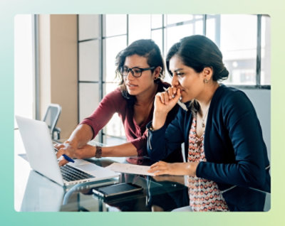 A couple of women looking at a laptop.