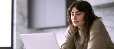 Person using a laptop at a desk in a modern indoor setting. Provide your feedback on BizChat