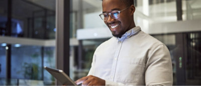 A man holding a tab in his hand and smiling.