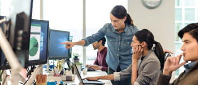 A woman pointing at a computer screen.
