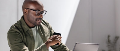 A person wearing glasses looking at the laptop