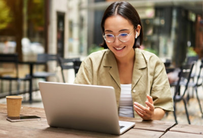 A woman sitting at a table using a laptop.