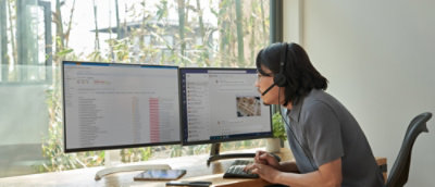 A women working on two computer.