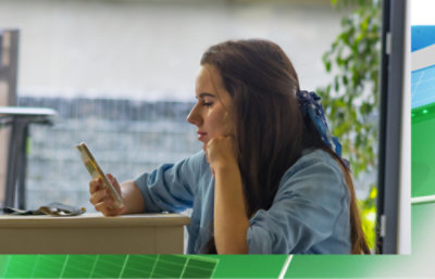 A person sitting at a table looking at a phone