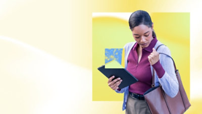 A women holding a tab and looking into her bag.