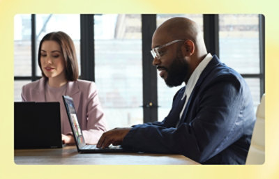A women and a man working with laptop in office desk.