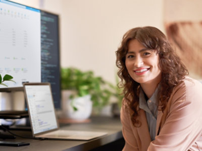 Women working in laptop and looking at the camera and smiling