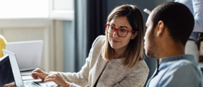 women with glasses looking at the screen