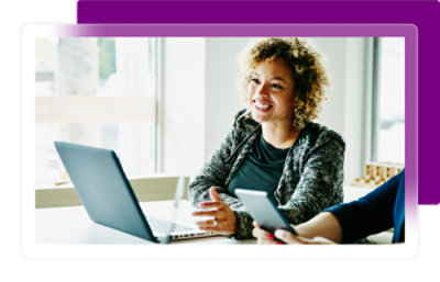 A women sitting on a desk with a laptop
