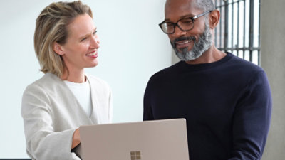 A man and woman looking at a laptop.