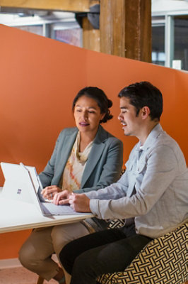 A man and woman looking at a laptop.