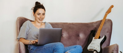 A person sitting on a couch using a laptop.