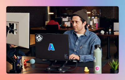 A man wearing cap looking at a computer.
