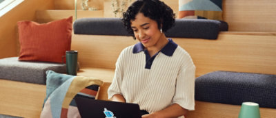 A woman looking at a laptop.