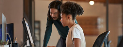 Two people looking at a laptop and having a discussion.