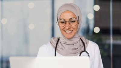 A doctor looking at the laptop.