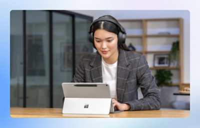A woman wearing headphones and using a tablet.