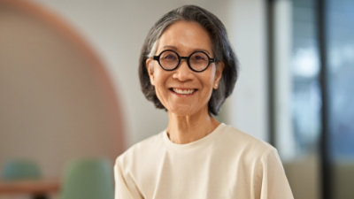 A woman wearing glasses and smiling.