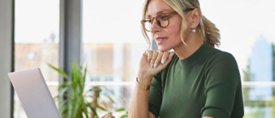 A woman wearing glasses and a green shirt with a ponytail.