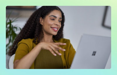 Person smiling and gesturing while using a laptop