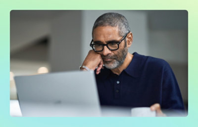Person with glasses focused on a laptop