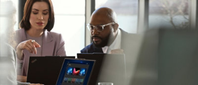 Group reviews content together on laptops in a meeting.