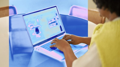Person typing on laptop with thermal-style overlay.