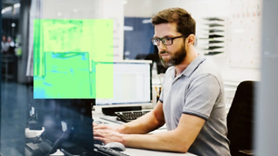 Person using computer with heatmap overlay on screen.