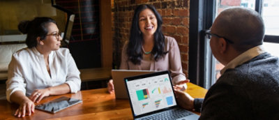 A man speaking with two woman