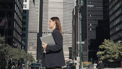 A women holding a laptop and looking somewhere.